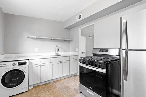 a kitchen with white cabinets and stainless steel appliances